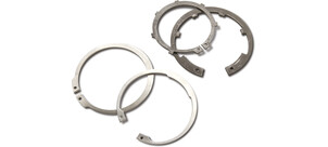 Mehrere metallische Sicherungselemente-Ringe liegen auf einer Fläche.