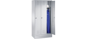 Ein aufgeschlossener Spind zeigt blaue Arbeitskleidung und einen weißen Schutzhelm im Inneren.